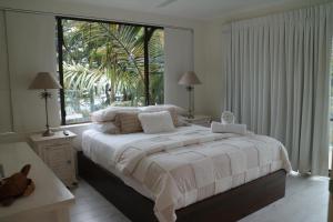 um quarto com uma cama grande e uma janela grande em Noosa Place Resort em Noosaville