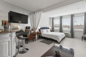 ORCHID SUITES - Historic Palm Beach Hotel Condominium في بالم بيتش: غرفة فندق بسرير ومكتب وغرفة نوم