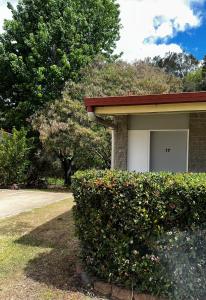 a building with a bush in front of a garage at Murgon Motor Inn in Murgon