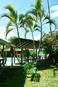 a group of tables and chairs and palm trees at Hotel El Bohio in Guaduas