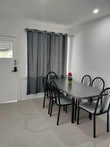 een eetkamer met een tafel en stoelen en een raam bij Joshi's Villa in Seymour