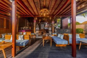 un patio al aire libre con muebles de madera y una mesa. en Pertiwi Bisma Ubud en Ubud