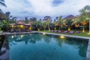 a swimming pool in a resort at night at Pertiwi Bisma Ubud in Ubud