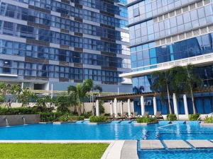 a swimming pool in front of two tall buildings at Spacious 2BR Apartment in BGC with Workspace & Washer in Manila