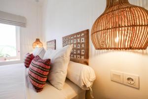 a bedroom with a bed with pillows and a lamp at The Room Padang-Padang in Uluwatu