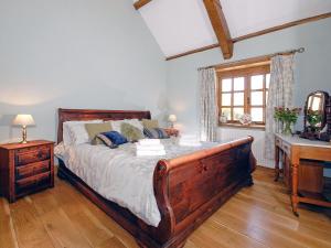 Schlafzimmer mit einem Bett, einem Schreibtisch und einem Fenster in der Unterkunft Yr Hen Glowty in Little Newcastle