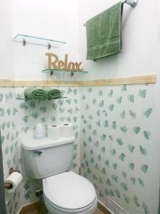 a bathroom with a toilet and a green towel at Luminoso y Acogedor Apto en Casco Viejo c/balcón in Panama City