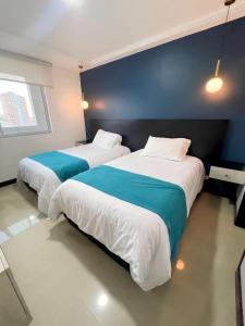 dos camas sentadas una al lado de la otra en una habitación en Atlantis Suites Bquilla -Apartamento Moderno-2-BD en Barranquilla