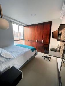 a bedroom with a bed and a desk and a chair at Atlantis Suites Bquilla -Apartamento Moderno-2-BD in Barranquilla