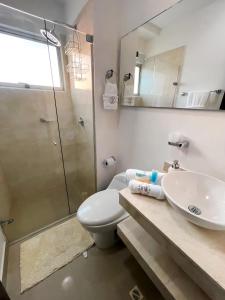 y baño con aseo, lavabo y ducha. en Atlantis Suites Bquilla -Apartamento Moderno-2-BD en Barranquilla