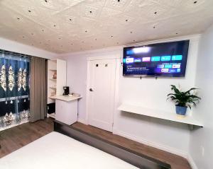 um quarto com uma televisão de ecrã plano na parede em New Renovated Cozy Bedroom with Private washroom em Toronto