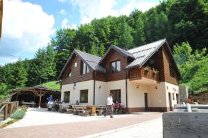 a man walking past a building with people sitting at Motel Luka in Deževice