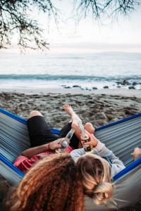 two girls laying on a hammock on the beach at Zazu Campers in Kahului