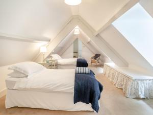 a attic bedroom with two beds and a desk at The Carriage House in Llanwenarth