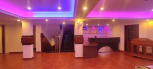 um quarto com um piano e um palco com luzes roxas em STONAGE TOURIST COMPLEX em Idukki