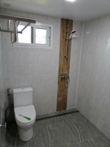 a bathroom with a toilet and a shower with a window at Mister check paradise in Si Chiang Mai