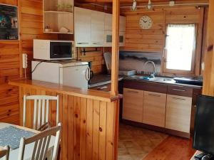 a kitchen with wooden cabinets and a counter with a sink at A comfortable house with a private garden, Rusinowo in Rusinowo