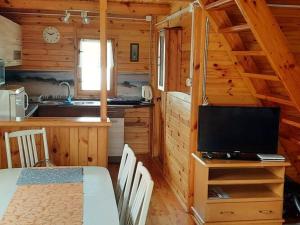 a room with a kitchen and a television in a cabin at A comfortable house with a private garden, Rusinowo in Rusinowo