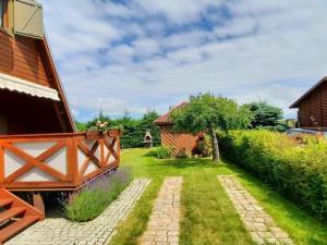 a garden with a house and a brick walkway at A comfortable house with a private garden, Rusinowo in Rusinowo