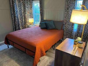 um quarto com uma cama com um edredão laranja em Cape Cod on Broad em Ashland