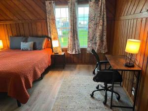 1 dormitorio con cama, escritorio y silla en Cape Cod on Broad, en Ashland