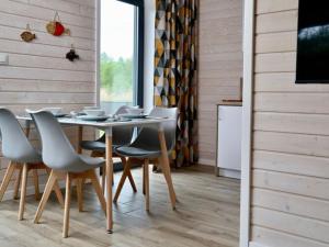 une salle à manger avec une table, des chaises et une télévision dans l'établissement A comfortable semi-detached house by the beach in Stepnica, à Stepnica
