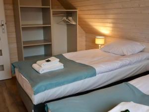 um quarto com uma cama grande e toalhas em A comfortable semi-detached house by the beach in Stepnica em Stepnica