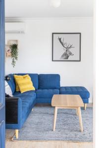 a blue couch in a living room with a table at Pet and family friendly- with its own lake and 3 mins from town! in Maleny