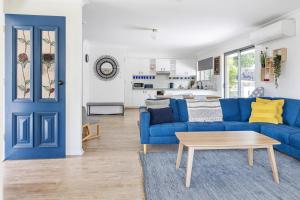 a living room with a blue couch and a table at Pet and family friendly- with its own lake and 3 mins from town! in Maleny