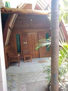 Elle offre une vue sur une maison en bois dotée d'une terrasse couverte. dans l'établissement Mirna Homestay, à Gili Air