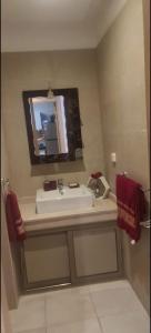 ein Bad mit einem Waschbecken und einem Spiegel in der Unterkunft Magnifique appartement Les perles de marrakech lux avec 2 piscines in Marrakesch