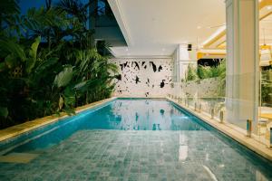 a swimming pool in a hotel with plants at Casa Amarta Canggu - Boutique Lofts & Detox SPA in Canggu