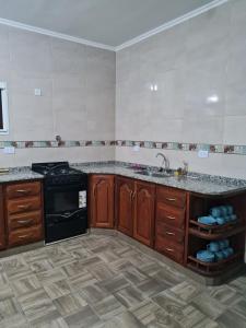 uma cozinha com um lavatório e um fogão em Dtos El Descanso em Termas de Río Hondo