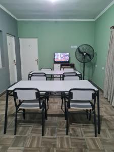 Sala de conferencias con mesas, sillas y TV en Dtos El Descanso en Termas de Río Hondo