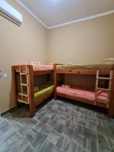 two bunk beds in a room with a tile floor at Dtos El Descanso in Termas de Río Hondo