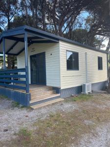 a tiny house with a porch and a deck at Second Valley Caravan Park in Second Valley