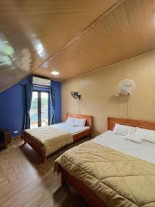 two beds in a room with blue walls at The Mountain View Homestay in Ninh Binh