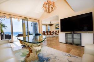 sala de estar con mesa de cristal y TV de pantalla plana en Private Beach front 4bed 4bath pool and spa house, en San Diego