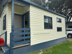 a tiny house with a porch and a door at Second Valley Caravan Park in Second Valley