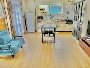 a living room with a couch and a table in a kitchen at 恩納ゆんたく-SEVEN Hotels and Resorts- in Onna
