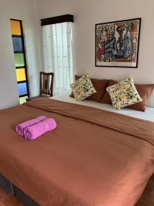 a bedroom with a large bed with pink towels on it at Villa Formosa Panglao in Panglao Island