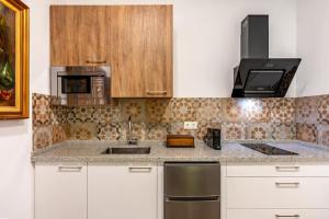 a kitchen with a sink and a microwave at Alojamiento Rural Molino Del Puente in Dúrcal