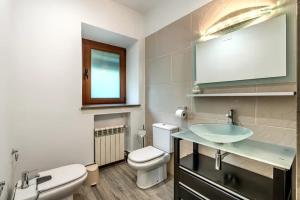a bathroom with a sink and a toilet and a mirror at Alojamiento Rural Molino Del Puente in Dúrcal
