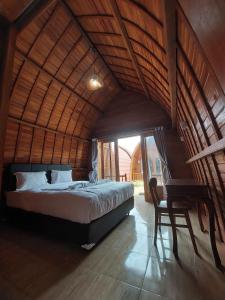 a bedroom with a large bed in a bamboo room at Les Chalets Pecatu in Uluwatu