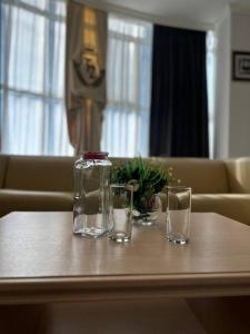 due bicchieri e un barattolo di vetro su un tavolo di Tanzharyk Hotel ad Aqtöbe