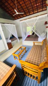 a room with two beds with nets on them at Emma's Sea View in Hiriketiya