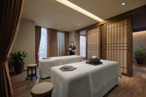 a woman standing in a hotel room with two beds at Hotel de l'Opera Hanoi - MGallery in Hanoi +37 photos
