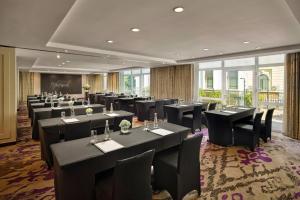 a restaurant with black tables and chairs and windows at Hotel de l'Opera Hanoi - MGallery in Hanoi