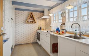 a kitchen with white cabinets and a sink at Cozy Apartment In Faaborg With Kitchen in Fåborg