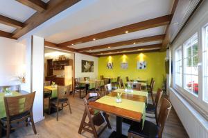 a restaurant with wooden tables and chairs and yellow walls at Hotel Garni Schilling in Duisburg